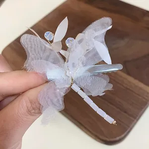 Gros plan d'une pince à cheveux papillon en dentelle blanche avec perles de cristal