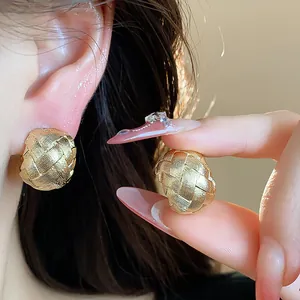 Dettaglio di orecchini a clip placcati oro 18k con trama intrecciata per donne