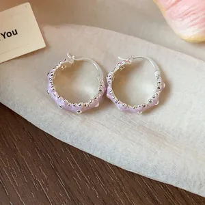 Detail view of sweet purple enamel flower hoop earrings with a silver-toned finish