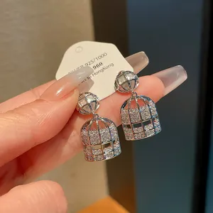 Detalle de los pendientes de jaula con pavé de circonitas brillantes en etiqueta