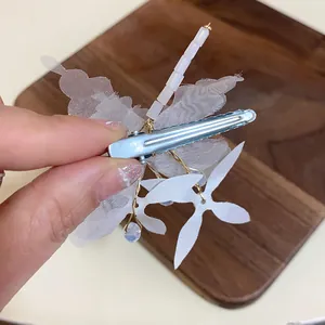 Vue détaillée de l'arrière de la barrette fleurs blanches montrant le clip en métal