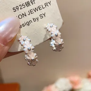 Close-up of sweet pink enamel flower hoop earrings with refined silver details