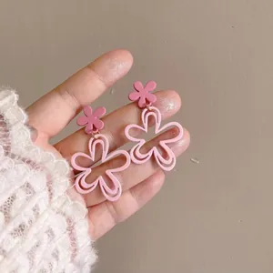 Close-up detail of stylish pink layered acrylic flower drop earrings with silver needles