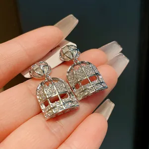 Detalle de pendientes de jaula con circonitas y perla en plata de ley artesanal