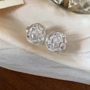 Dettaglio macro del complesso design a sfera cava intrecciata in argento di questi orecchini