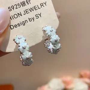 Detail view of sweet mint green enamel flower hoop earrings with fine silver accents