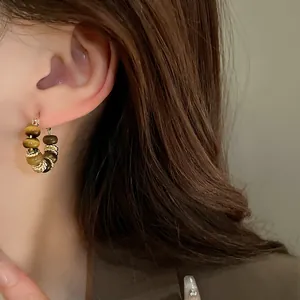 Close-up detail view of real gold plated tiger eye beaded hoop earrings for women