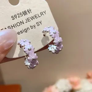Close-up detail of sweet purple oil-dripping flower hoop earrings on display card