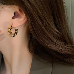 Detailed view of gold-plated hoop earrings featuring natural tiger eye stone beads