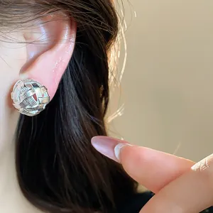Dettaglio ravvicinato di orecchino a clip intrecciato cavo placcato oro 18k