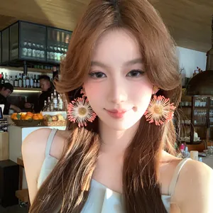 Sweet peach-colored flower fringe tassel earrings worn by a model in warm light