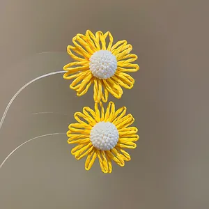 Detailed close-up view of yellow flower earrings with intricate white beaded centers.