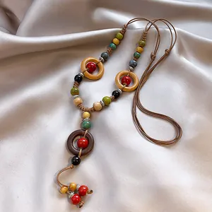Vue détaillée d'un collier ethnique avec des perles en céramique et en bois.