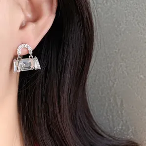 Detailed shot of elegant silver bag-shaped stud earrings with sparkling crystals