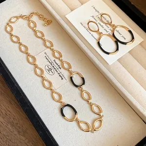 Nahaufnahme eines goldenen Vintage-Schmucksets mit schwarzen Emaille-Akzenten in Box.