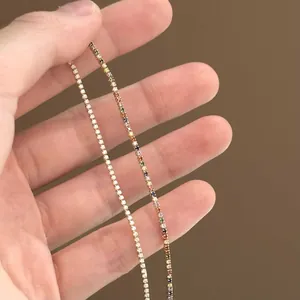 Vue détaillée de bracelets de tennis en plaqué or avec zircons arc-en-ciel et clairs.