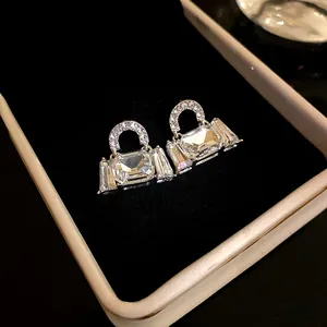 Detailed macro view of handbag-shaped earrings with sparkling cubic zirconia crystals