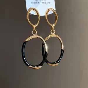 Detailansicht retro unregelmäßige ovale Ohrhänger mit Gold- und schwarzer Emaille-Oberfläche