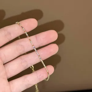 Vue détaillée d'un élégant bracelet tennis en or orné de zircons carrés colorés