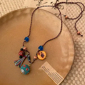 Vista dettagliata della collana etnica retrò con perle di ceramica e ciondolo a nappa.