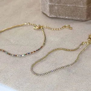 Gros plan détaillé de bracelets tennis dorés minimalistes avec zircons clairs et colorés