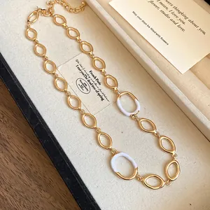 Detaillierte Nahaufnahme einer vergoldeten ovalen Gliederkette mit weißer Emaille