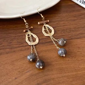 Detailed view of bohemian irregular gold hollow earrings with wooden accents