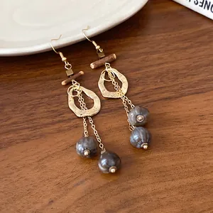 Detail of retro ethnic earrings with hollow gold hoops and marbled wooden beads