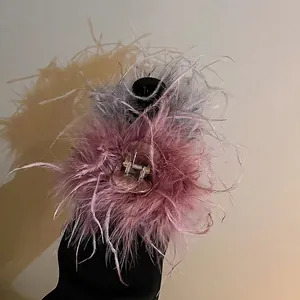 Elegant ostrich feather hair claw clip in purple and grey for a sophisticated hair style.