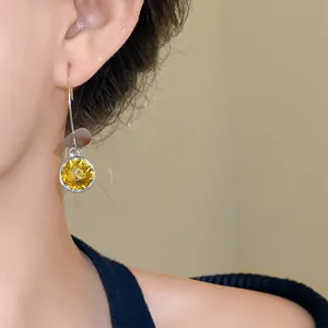 Primo piano di orecchini vintage con cristallo giallo e dettaglio in metallo argento
