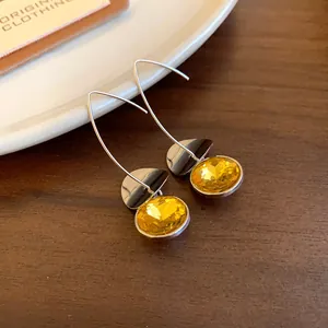 Dettaglio di eleganti orecchini geometrici vintage con pietre sfaccettate giallo brillante