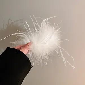Detail view of fluffy white ostrich feather hair claw clip with delicate texture