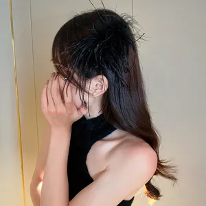 Detailed side view of an elegant black ostrich feather hair claw clip worn by a model.