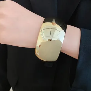 Stylish statement chunky gold acrylic cuff bracelet with geometric faceted design for women.