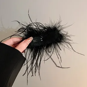 Close-up view of the back side mechanism of the fluffy black ostrich feather hair clip
