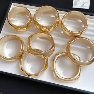 Detailed view of multiple golden acrylic geometric chunky bracelets in a display tray.