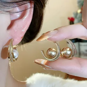 Primo piano dettagliato di orecchini vintage in oro con perle e pavé di zirconi cubici
