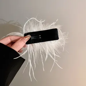 Back view detail of elegant white ostrich feather hair clip with black base
