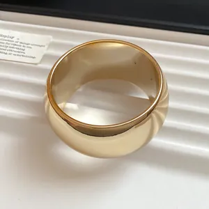 Detailed macro view of a chunky wide gold acrylic bracelet with a high gloss polished finish