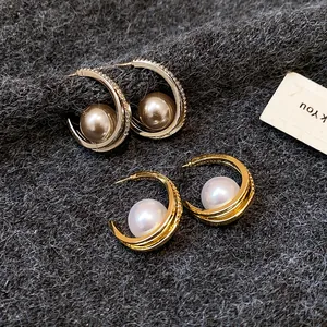 Dettaglio di eleganti orecchini di perle e zirconi stile francese in argento e oro