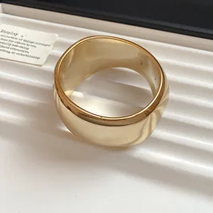 Close-up of a chunky geometric gold bangle with a high-polished metallic finish
