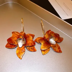 Macro detail of vintage fabric rose earrings with amber resin-like texture