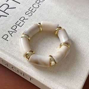 Macro view showing the detailed texture of marbled acrylic segments and gold metal spacers