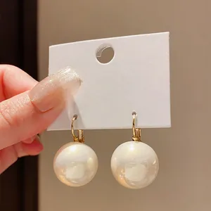 Eleganti orecchini pendenti con grandi perle bianche e chiusura dorata