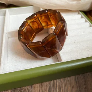 Detail of amber marbled acrylic chunky bracelet with rectangular segmented design.