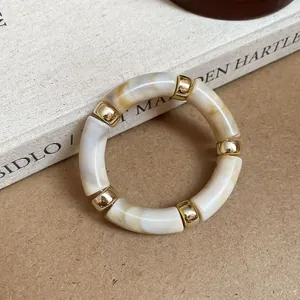 Close-up detail of a vintage marbled acrylic bracelet featuring polished golden spacers
