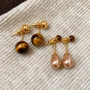 Vintage real gold plated tiger eye stone and teardrop pearl earrings on beige knitwear