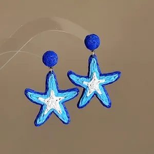 Handmade woven blue and white starfish earrings for a stylish beach vacation look