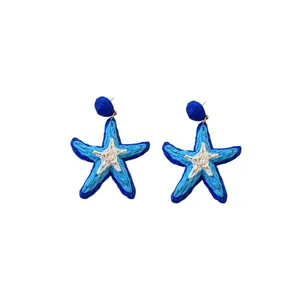 Handmade woven starfish earrings in blue and white for a stylish beach vacation look.