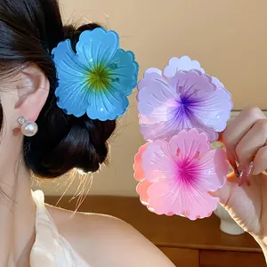 Close-up of vibrant pleated flower hair claws in pink, blue, and purple colors